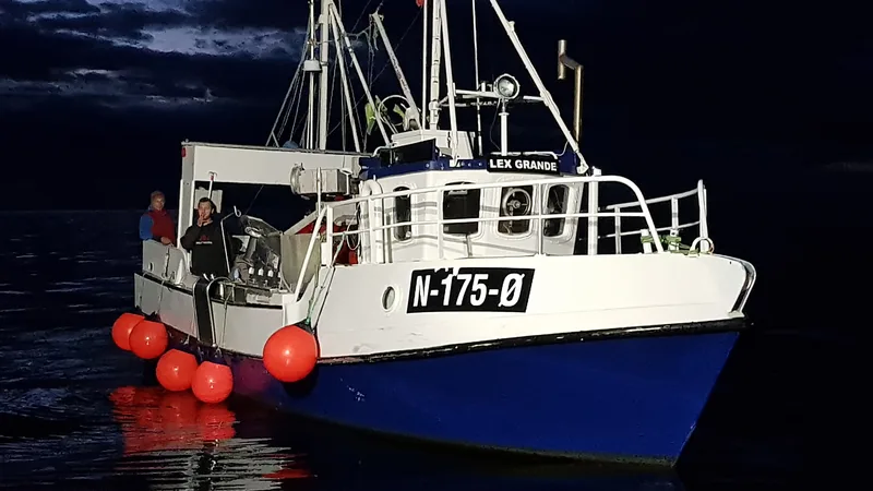 Mannskap som arbeider på dekket av en kystfiskebåt i skumring